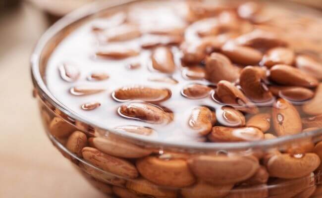 A bowl of pinto beans soaking in water.
