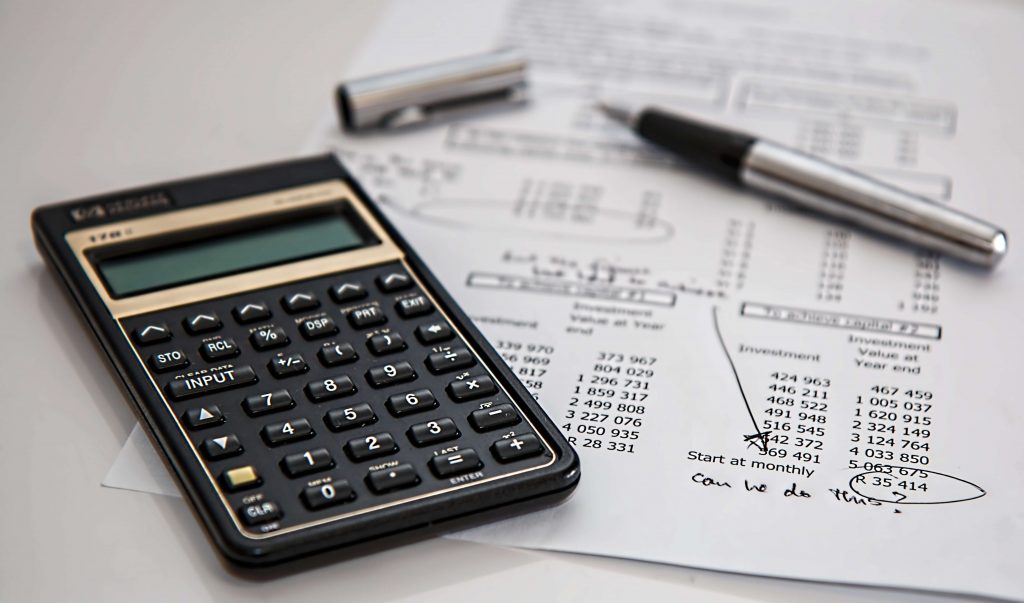 Calculator, pen, and land loan documents on a table