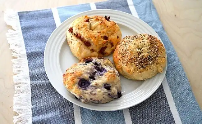 Three homemade bagels on a plate together.