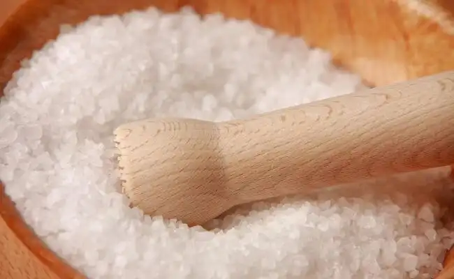 Course sea salt in a bowl with a fermenting pounder in it.