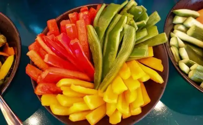 Slices of bell peppers and cucumbers in a bowl, the perfect vegetables to start fermenting for beginners.