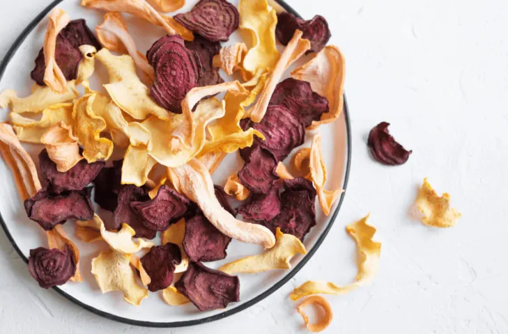 Dehydrated vegetables chips in a pile on a plate.