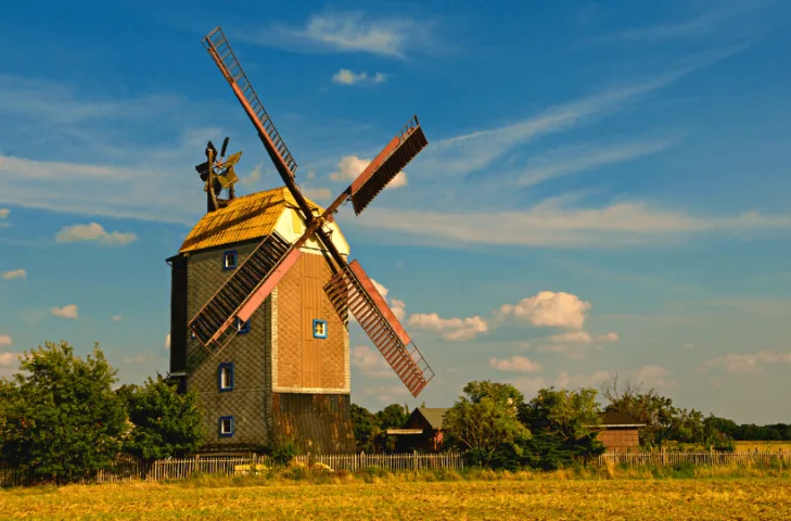 A windmill rotating in the wind outside as part of an off-grid power system.